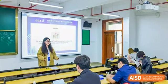 Students attending a class where a teacher is presenting content on a projector screen at Shenzhen International Foundation College (SIFC).