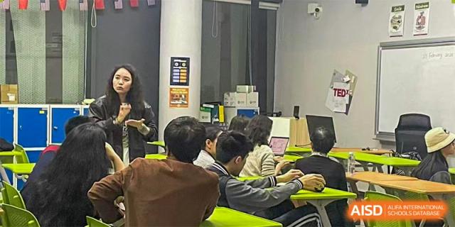 Students working on individual Apple desktop computers in a technology or coding classroom at Shenzhen International Foundation College (SIFC).