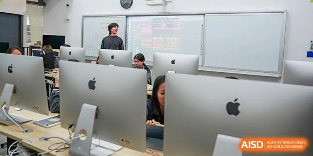 Students working on Apple desktop computers in a technology or media classroom at Shenzhen International Foundation College (SIFC).