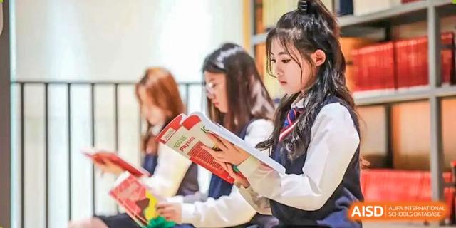 A group of female students looking at an open textbook during a study session at Shenzhen International Foundation College (SIFC).