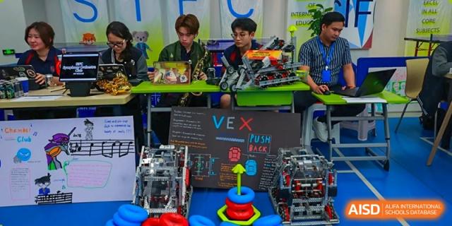 Students working on and demonstrating a VEX Robotics competition setup in a technology lab at Shenzhen International Foundation College (SIFC).
