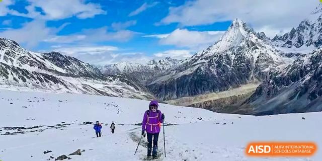 A person hiking or trekking across a snowy, mountainous landscape during an outdoor trip at Shenzhen International Foundation College (SIFC).