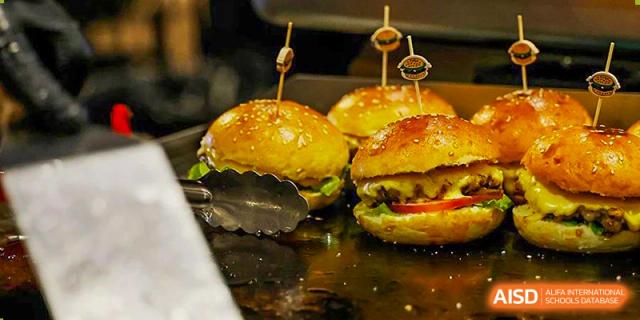 Freshly grilled cheeseburgers placed on a hot surface ready to be served in the cafeteria at Shenzhen International Foundation College (SIFC).