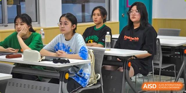 Female students from Suzhou Innovation Academy sitting at desks and attentively participating in a classroom discussion.
