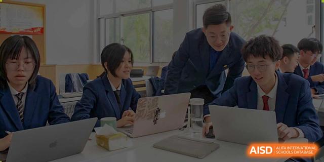A female student and male teacher from Suzhou Innovation Academy working together on a project using a laptop during a meeting.