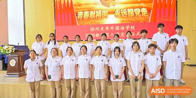 A large group of female students at Walton International School Xuzhou standing in uniform for a group photo during a school event or ceremony.