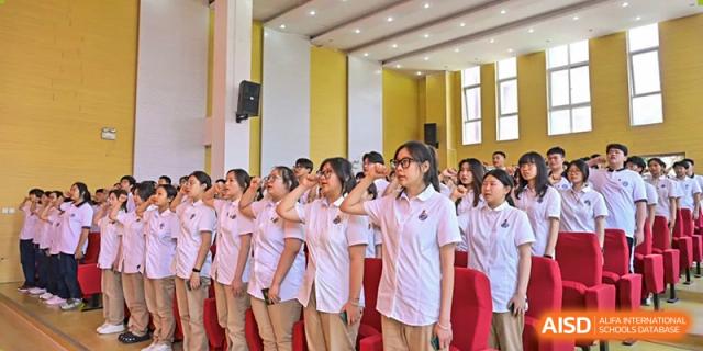 Female students at Walton International School Xuzhou standing together in uniform, smiling and posing during a large school event.