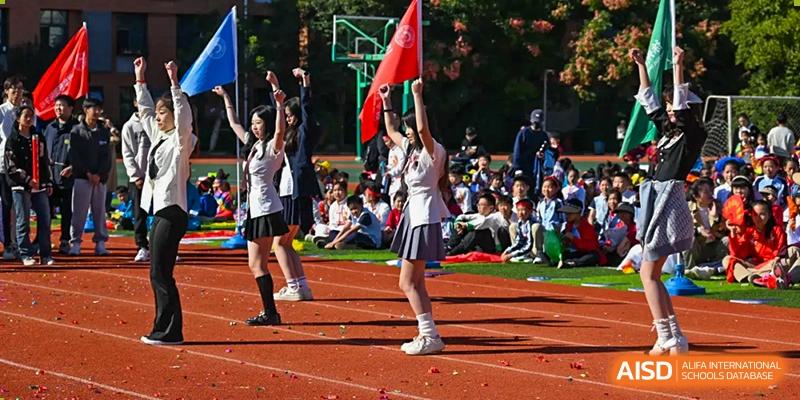 A cheerleader in uniform performing a stance on the track during a sports day event at Walton International School Xuzhou.