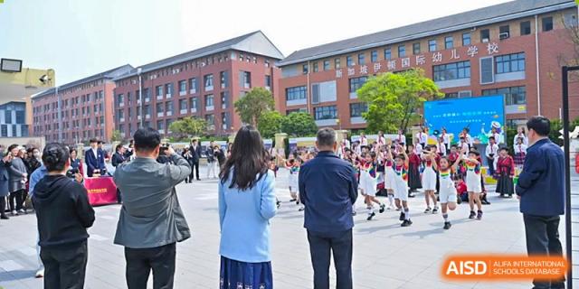 A crowd of students and parents gathered in the plaza outside the school building at Walton International School Xuzhou.