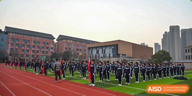 Students in uniform lined up for a formation or assembly in front of the main building of Walton International School Xuzhou.
