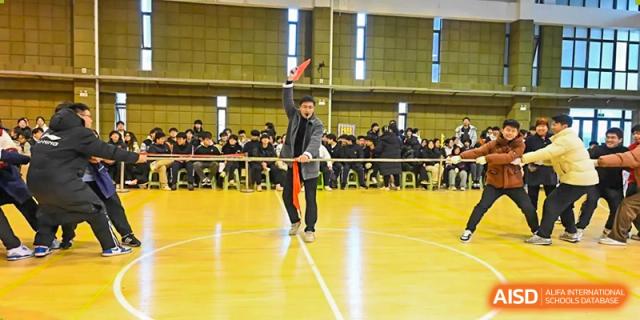 A student performing on a polished indoor court in front of an audience during a school event at Walton International School Xuzhou.