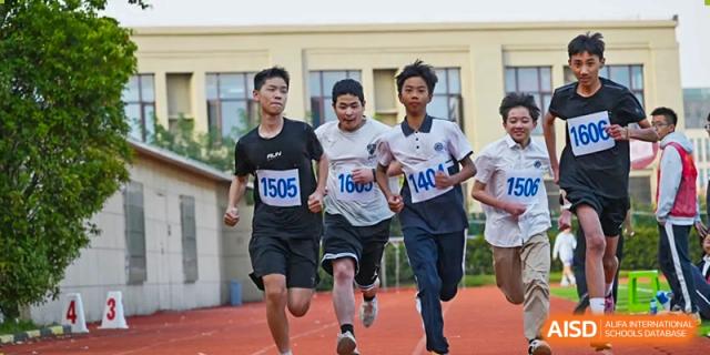 Three students running a race together on the track, competing in a long-distance event at Walton International School Xuzhou.