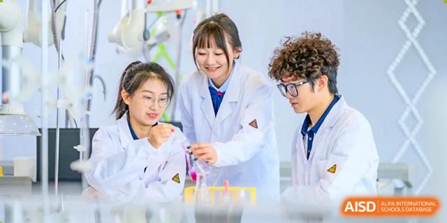 Wuxi Huatian Bilingual School students and a teacher in lab coats performing a colorful science experiment.