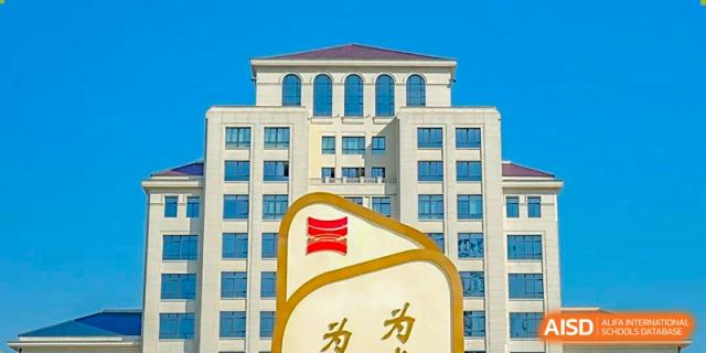 Modern multi-story academic building of Wuxi Huatian Bilingual School with large windows, featuring the school's red and white logo and name sign in the foreground.