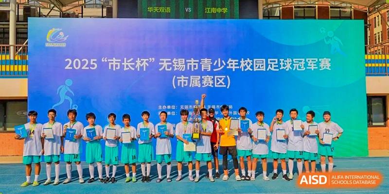 Group of students from Wuxi Huatian Bilingual School holding a trophy on a banner-backed stage after winning a competition (Wuxi Youth Campus Cup).
