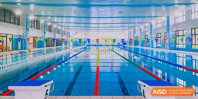 Indoor competition swimming pool lanes with starting blocks at Wuxi Huatian Bilingual School.