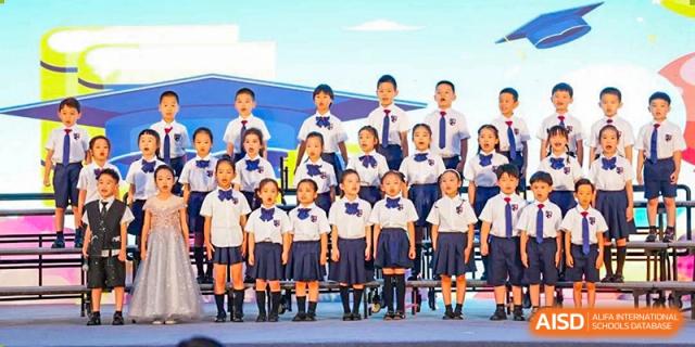 Group of young students from Wuxi Huatian Bilingual School in uniform performing as a choir on stage.