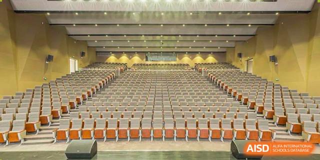 Large, modern Wuxi Huatian Bilingual School auditorium or hall with rows of empty seating.