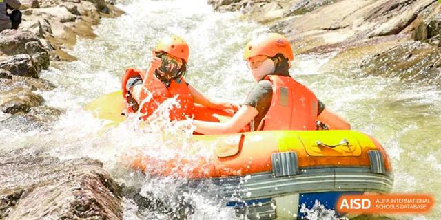 Students or staff from Wuxi Huatian Bilingual School engaging in an outdoor water rafting or rescue activity.