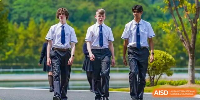 A line of Wycombe Abbey School Hangzhou students in uniform walking outdoors, led by a boy.