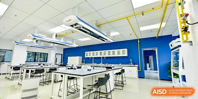 An interior view of a modern science laboratory or classroom at Wycombe Abbey School Hangzhou with white desks and blue accents.