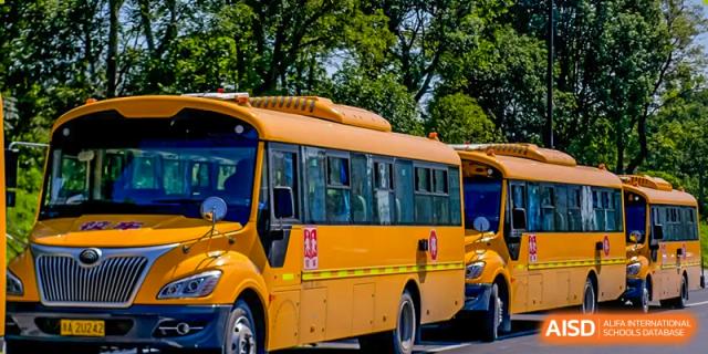 A bright yellow school bus, possibly a close-up of the front or side, associated with Wycombe Abbey School Hangzhou.