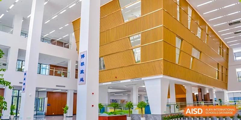 Modern school building exterior with a yellow-slatted facade and large windows at Wycombe Abbey School Hangzhou.