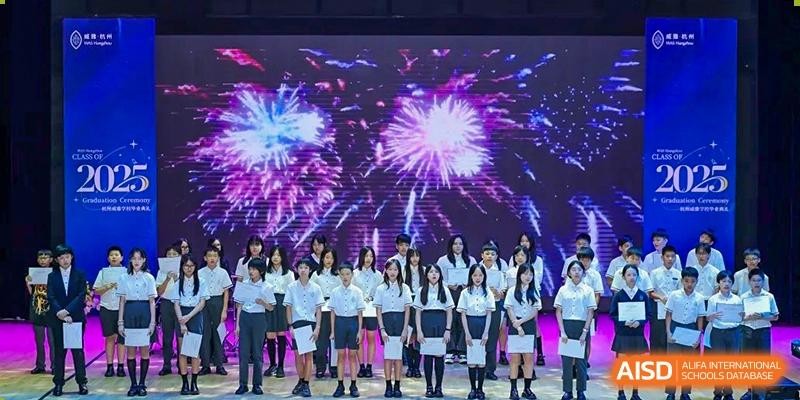 Students in uniform posing on stage in front of a digital display showing fireworks at Wycombe Abbey School Hangzhou.
