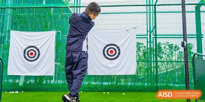 Student or instructor practicing golf swing toward a target on a green at Wycombe Abbey School Hangzhou.
