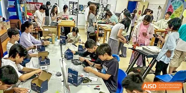 Xiamen International School students collaborating on a hands-on project with electronic components in a technology lab.