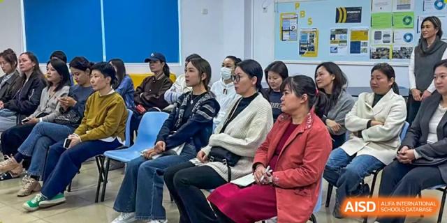 A group of Xiamen International School parents or adults seated and attending a school meeting or information session.