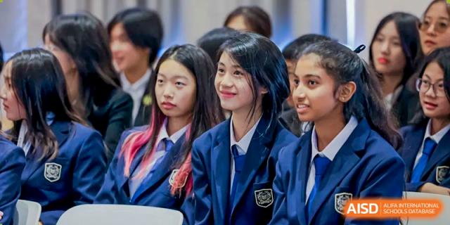 A close-up of smiling female Xiamen International School students in navy school blazers.