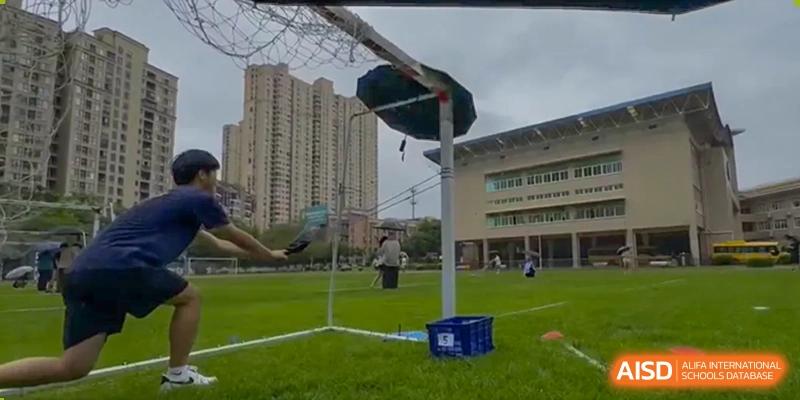 An outdoor view of the Xiamen International School playing field, with a goalpost set up against the backdrop of school buildings.