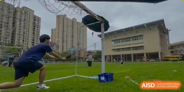 An outdoor view of the Xiamen International School playing field, with a goalpost set up against the backdrop of school buildings.