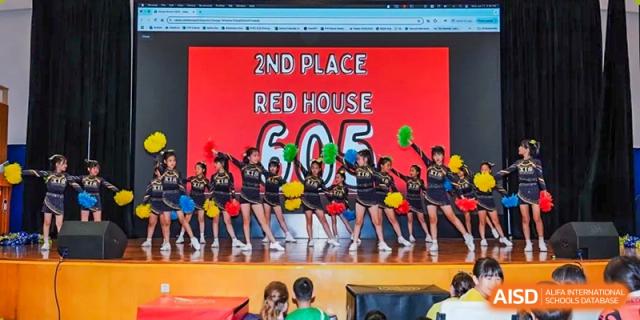 Xiamen International School students performing on stage, cheering for "Red House" which placed "2ND PLACE" with a score of "605."