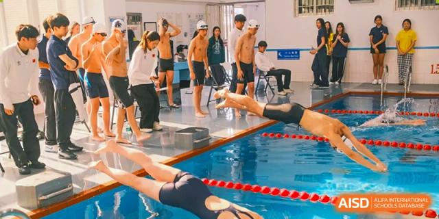 A group of Xiamen International School students standing by the edge of a swimming pool during a class or break.