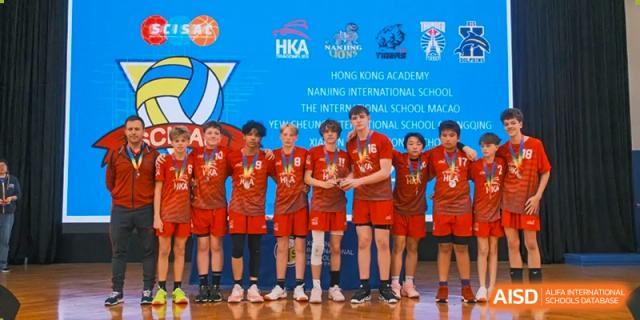 The Xiamen International School volleyball team posing for a group photo in their red jerseys after a tournament.