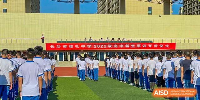A line of Yali High School International Department students in uniform standing on an outdoor track for an event or ceremony.