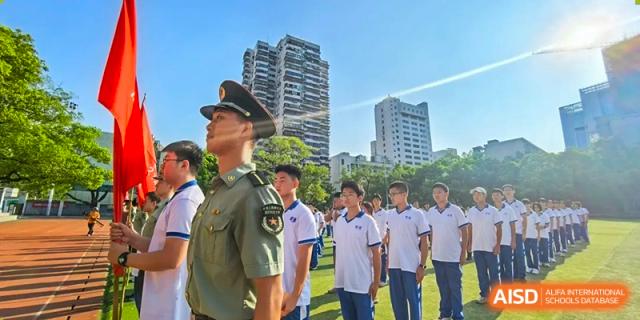 Yali High School International Department students standing in formation outdoors with a military or security officer.