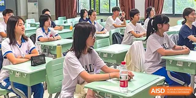 A Yali High School International Department female student conducting an experiment with glassware and red liquid in a science class.