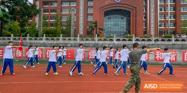 Yali High School International Department students exercising on an outdoor track in front of the school building.