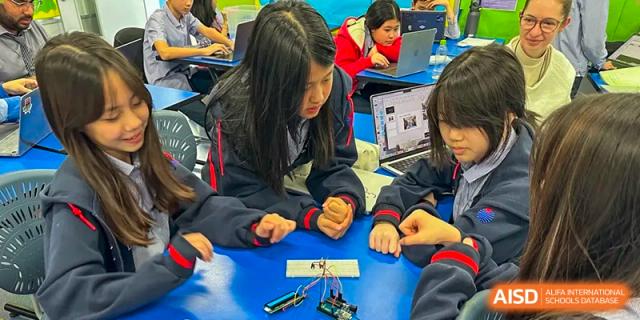 Two students at Yew Chung International School of Qingdao collaborating on a small hands-on project with building blocks in the classroom.