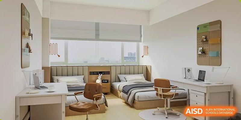 A view of a clean, modern dormitory room at Yew Chung International School of Qingdao with a single bed and wooden furnishings.