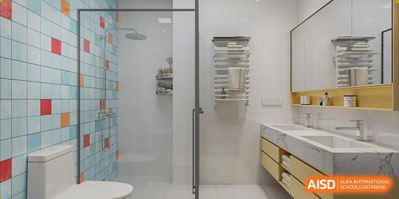 A view of a modern bathroom or shower area with a glass door and white shelving at Yew Chung International School of Qingdao dormitory.
