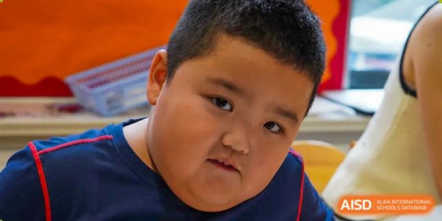 A close-up portrait of a young male student at Yew Chung International School of Qingdao with a serious expression.