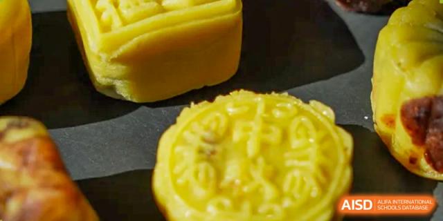 A close-up shot of a Mooncake, a traditional Chinese pastry, highlighting its texture and patterned design, possibly for a cultural event at Yew Chung International School of Qingdao.