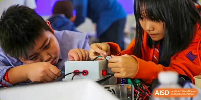Hands-on learning activity at Yew Wah International Education School of Zhejiang Tongxiang with a student connecting electronic components.