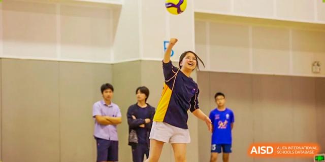 Yew Wah International Education School of Zhejiang Tongxiang student hitting a volleyball during a practice or game indoors.