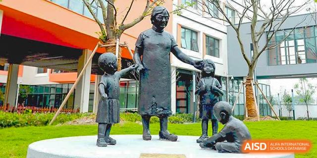 A bronze statue of a woman and children on the campus of Yew Wah International Education School of Zhejiang Tongxiang.