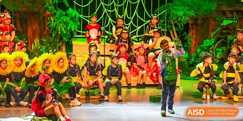 Students from Yew Wah International Education School of Zhejiang Tongxiang performing on stage in bright costumes.